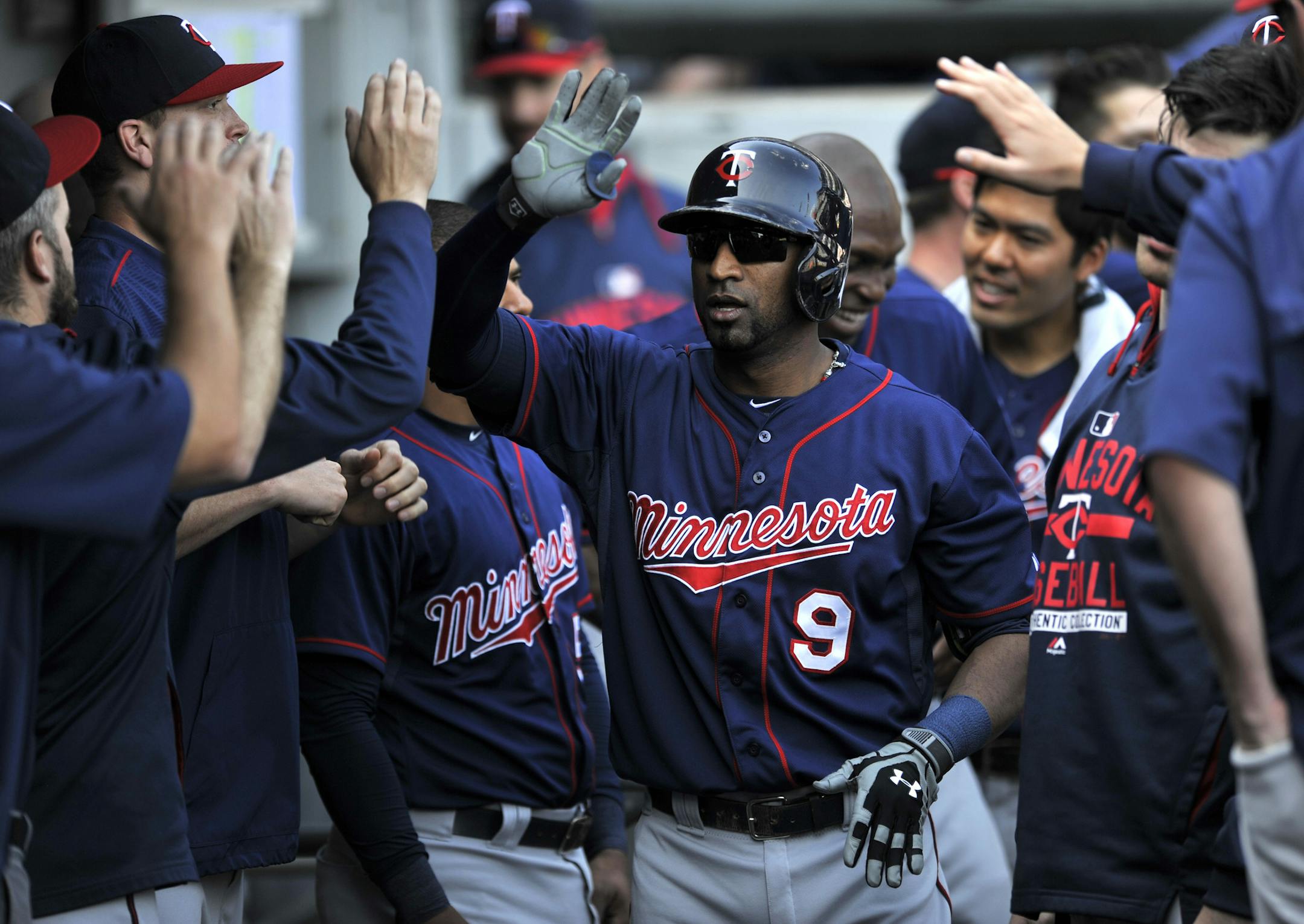 Minnesota Twins' Eduardo Nunez (9) celebrates with teammates in the dugout after hitting a solo home run during the second inning of a baseball game against the Chicago White Sox in Chicago, Saturday, May 23, 2015. (AP Photo/Paul Beaty)