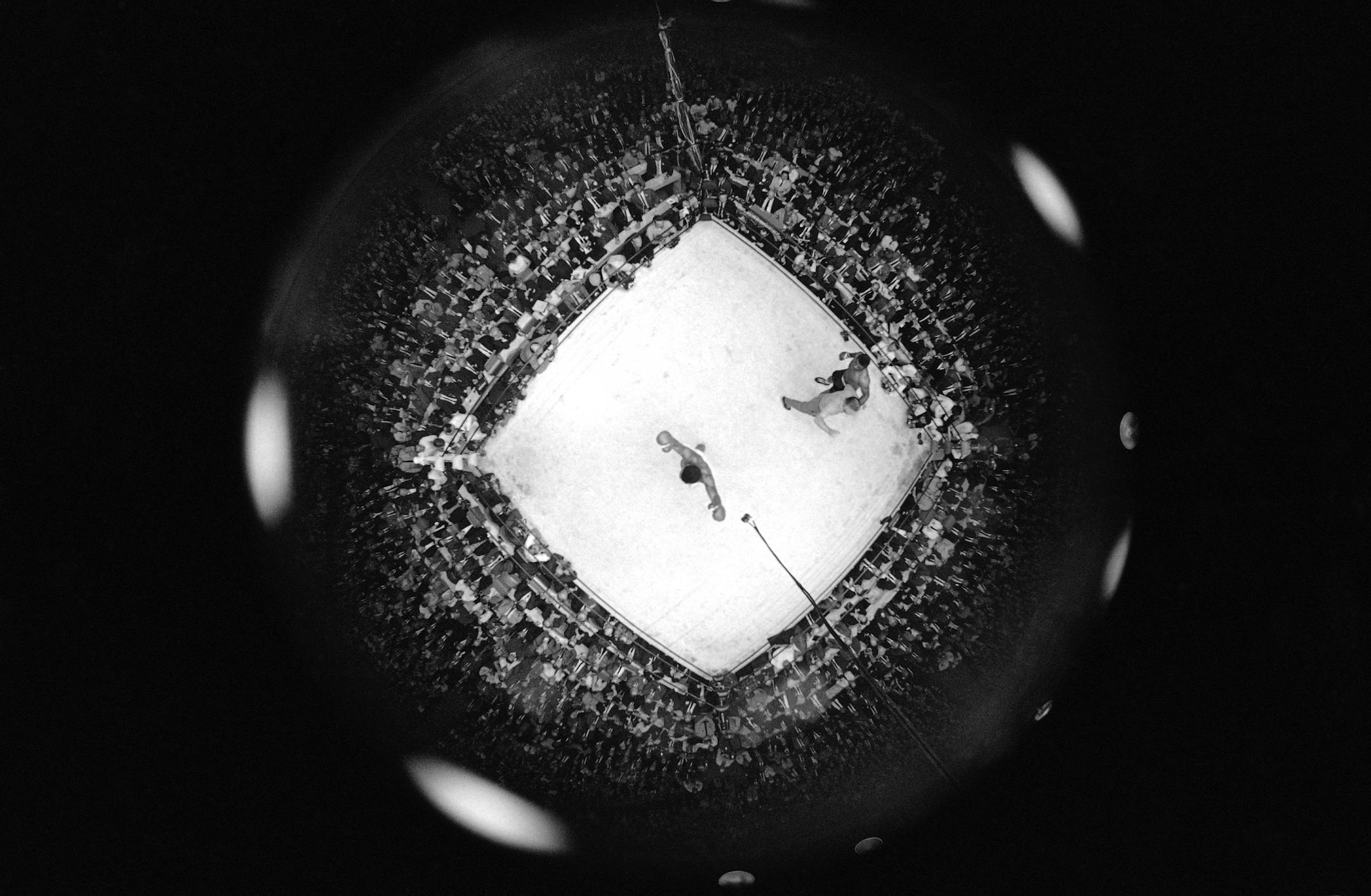 This ?fish-eye? camera view from the rafters shows the scene as referee Harry Krauch ended the heavyweight title fight on a 12th round technical knockout in Las Vegas, Nevada on Nov. 22, 1965. He is waving challenger Floyd Patterson away, as the still-champion Muhammad Ali ( Cassius Clay) raises his own hands in victory at ring?s center. (AP Photo) ORG XMIT: APHS278091
