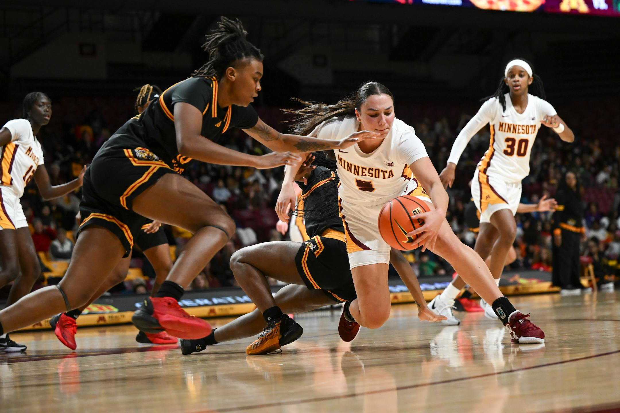 Grambling Lady Tigers guard Jordyn Carter (23), left, and guard Arianna Mosley (3) battle for the ball against Minnesota Gophers guard Maggie Czinano (5) in the second half.