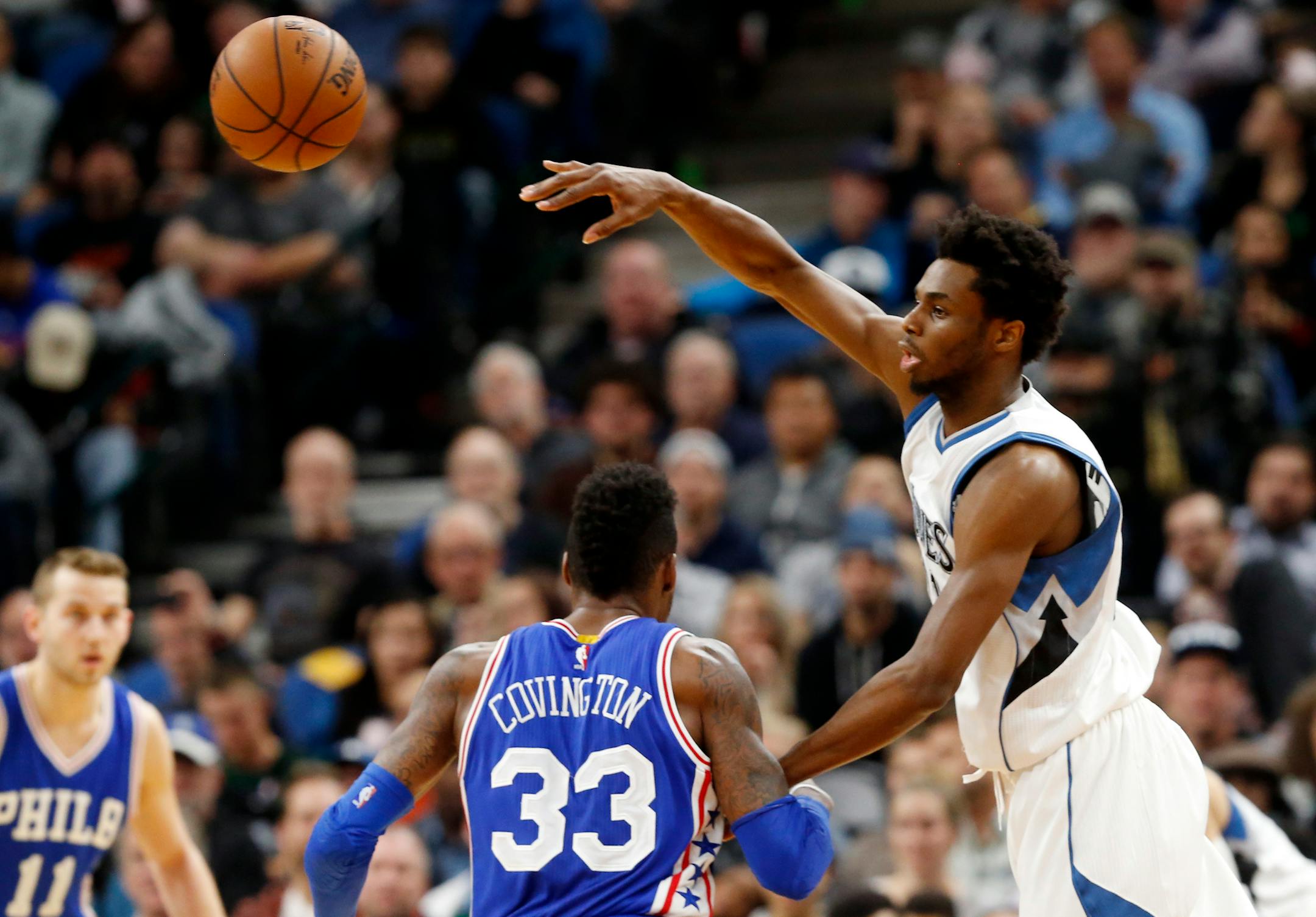 Minnesota Timberwolves' Andrew Wiggins, right, sends a pass over Philadelphia 76ers' Robert Covington in the second half of an NBA basketball game Thursday, Nov. 17, 2016, in Minneapolis. The Timberwolves won 110-86. Wiggins led the Timberwolves with 35 points. (AP Photo/Jim Mone)