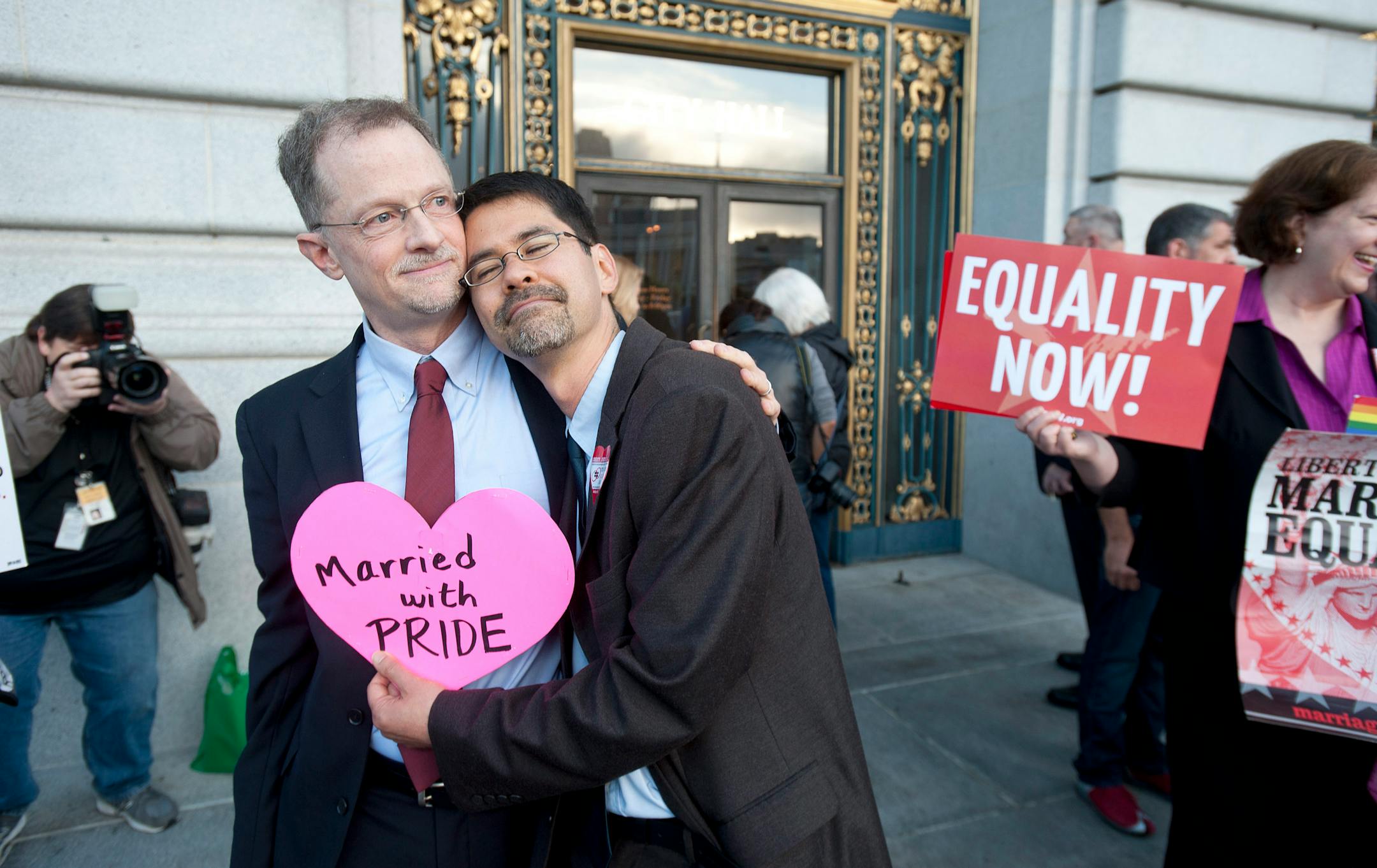 John Lewis, left, and Stuart Gaffney embrace outside San Francisco's City Hall shortly before the U.S. Supreme Court ruling cleared the way for same-sex marriage in California on Wednesday, June 26, 2013. The justices issued two 5-4 rulings in their final session of the term. One decision wiped away part of a federal anti-gay marriage law that has kept legally married same-sex couples from receiving tax, health and pension benefits. The other was a technical legal ruling that said nothing at all