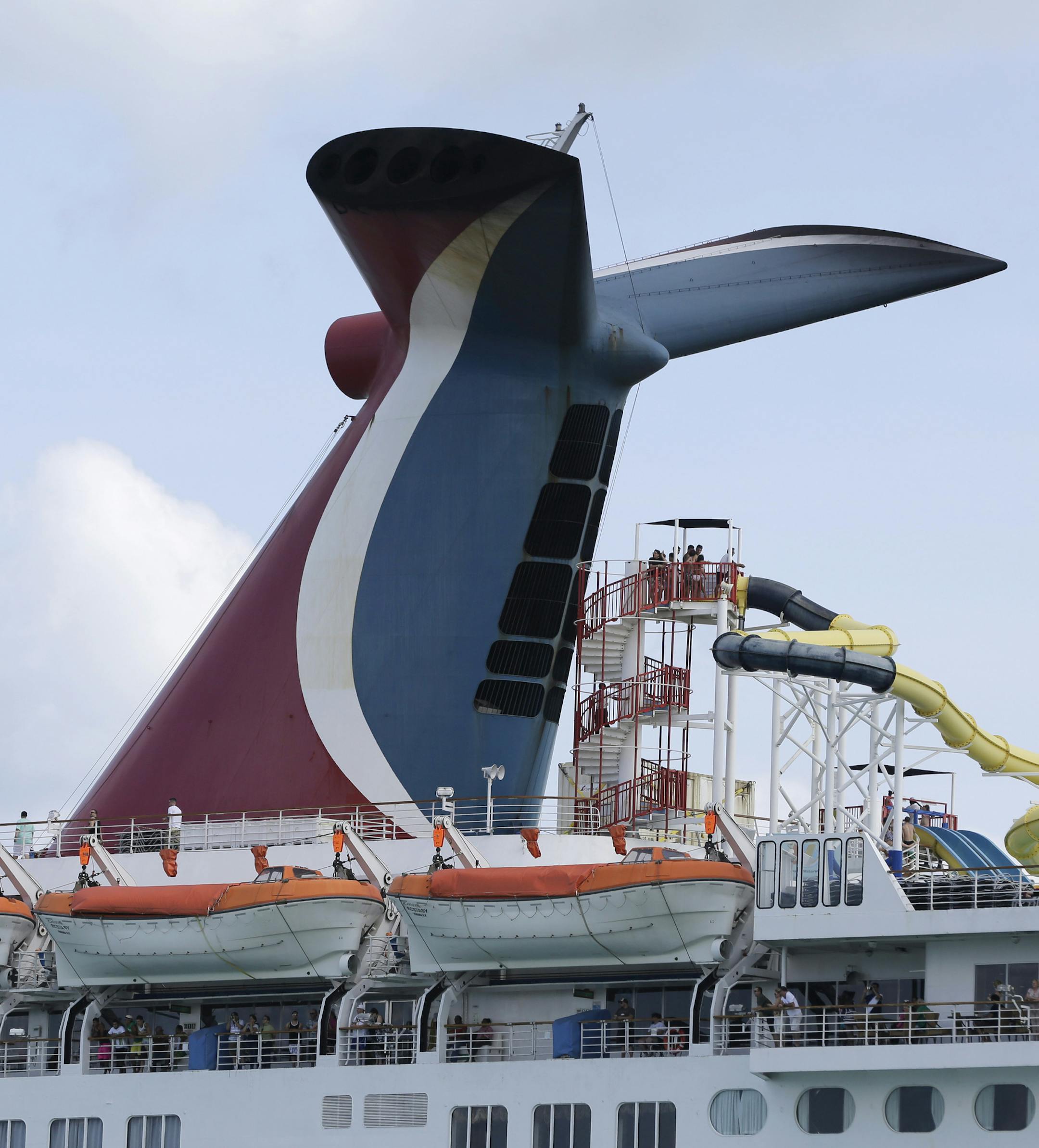 In this Monday, May 19, 2014 photo, the Carnival Cruise Lines ship Ecstasy leaves the Port of Miami as it passes Miami Beach, Fla. (AP Photo/Lynne Sladky)