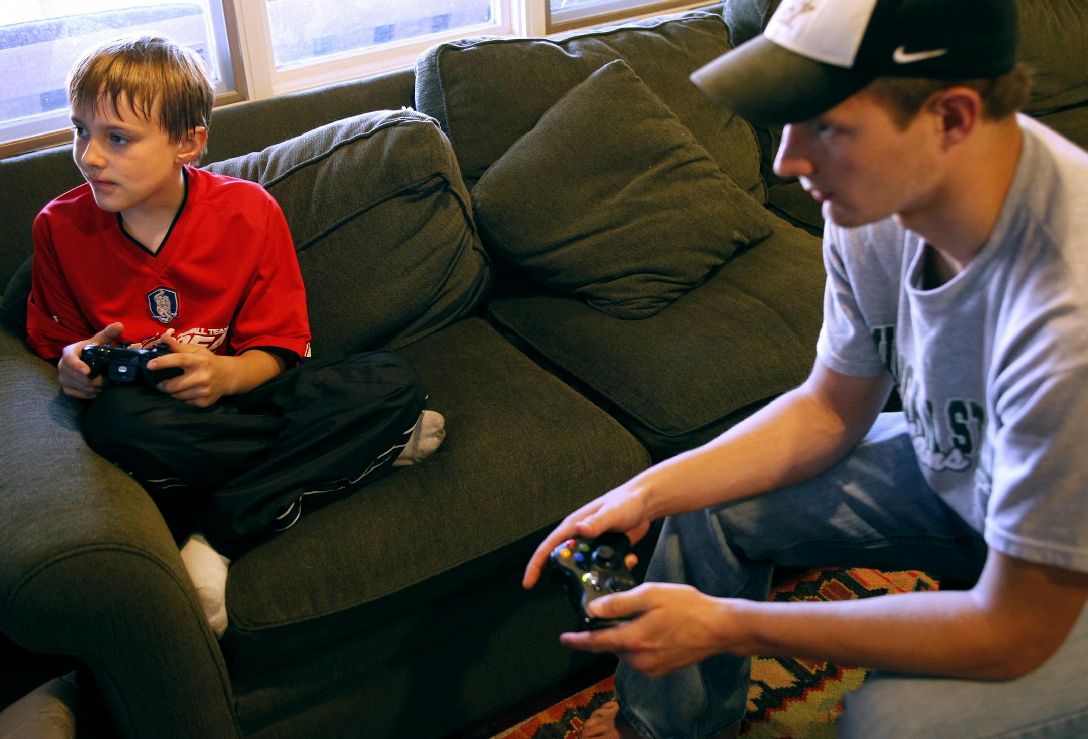 Jared Monsebroten, 19, and Sam Smith, 10, played video games. Jared is a "manny," a nanny who happens to be a guy.