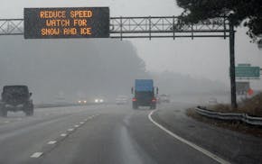 An electronic sign reads "REDUCE SPEED WATCH FOR SNOW AND ICE" as vehicles move along Interstate 40 on Jan. 17, 2018, in Morrisville, North Carolina.