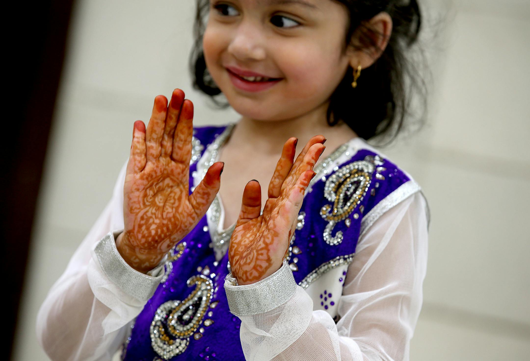 Samrah Khan, 5, showed off her Eid al-Fitr holiday dress and henna at a community breakfast at the Islamic Center of Minnesota in Fridley on Monday.
