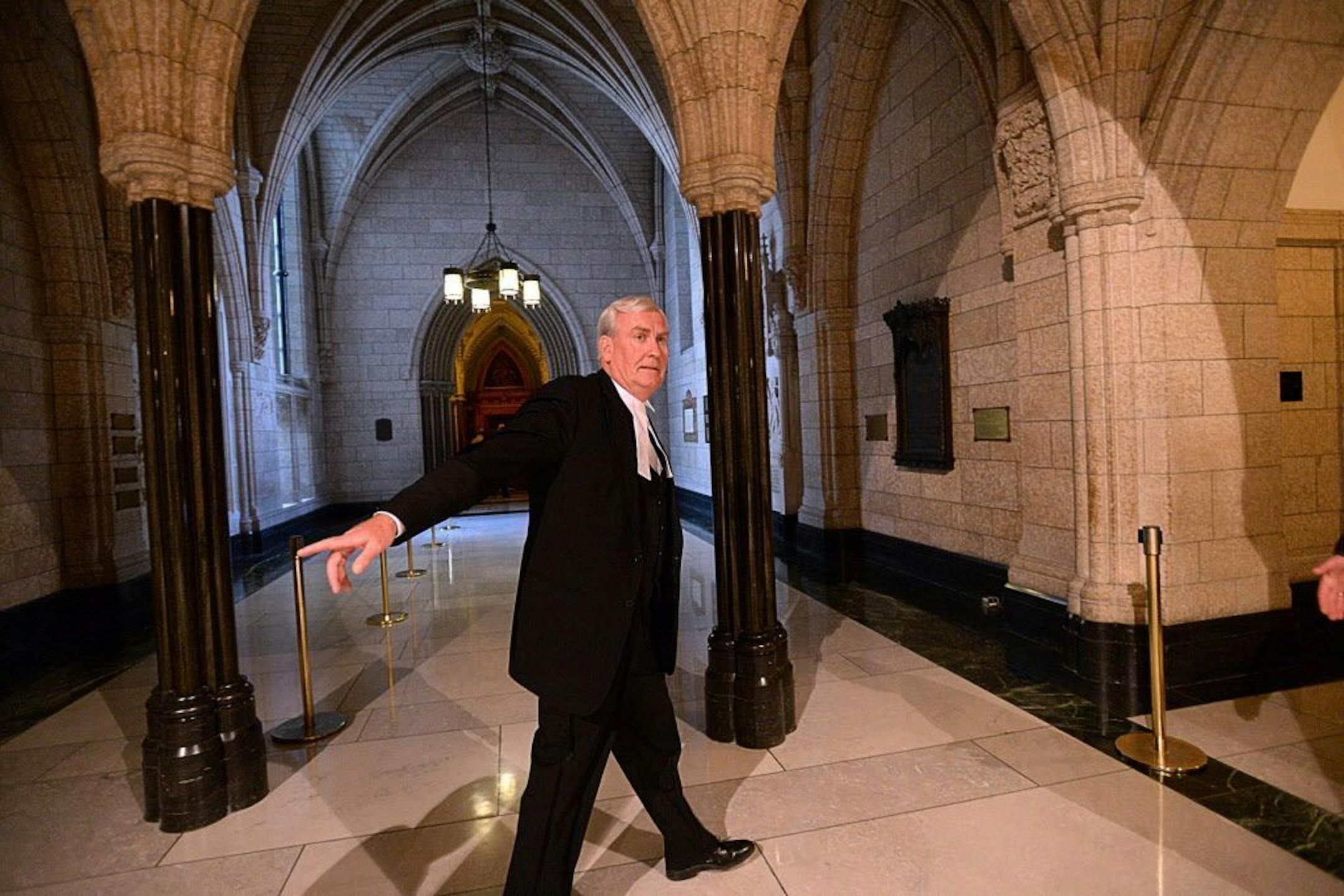 Kevin Vickers, sergeant-at-arms of the House of Commons, walks Thursday Oct. 23, 2014 past the library where Michael Zehaf Bibeau was gunned down the day before, in Ottawa, Ontario.