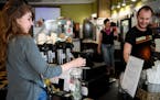 Barista Andy Regan, right, watched as Jennifer Ivers, of Minneapolis, placed a dollar in the tip jar Wednesday afternoon at Maeve's Cafe. ] AARON LAVI