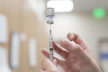 A health care worker prepares a dose of the Pfizer-BioNTech Covid-19 vaccine.