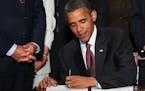 U.S. President Barack Obama signs the Dodd-Frank Wall Street Reform and Consumer Protection Act at the Ronald Reagan Building in Washington, D.C., Wed