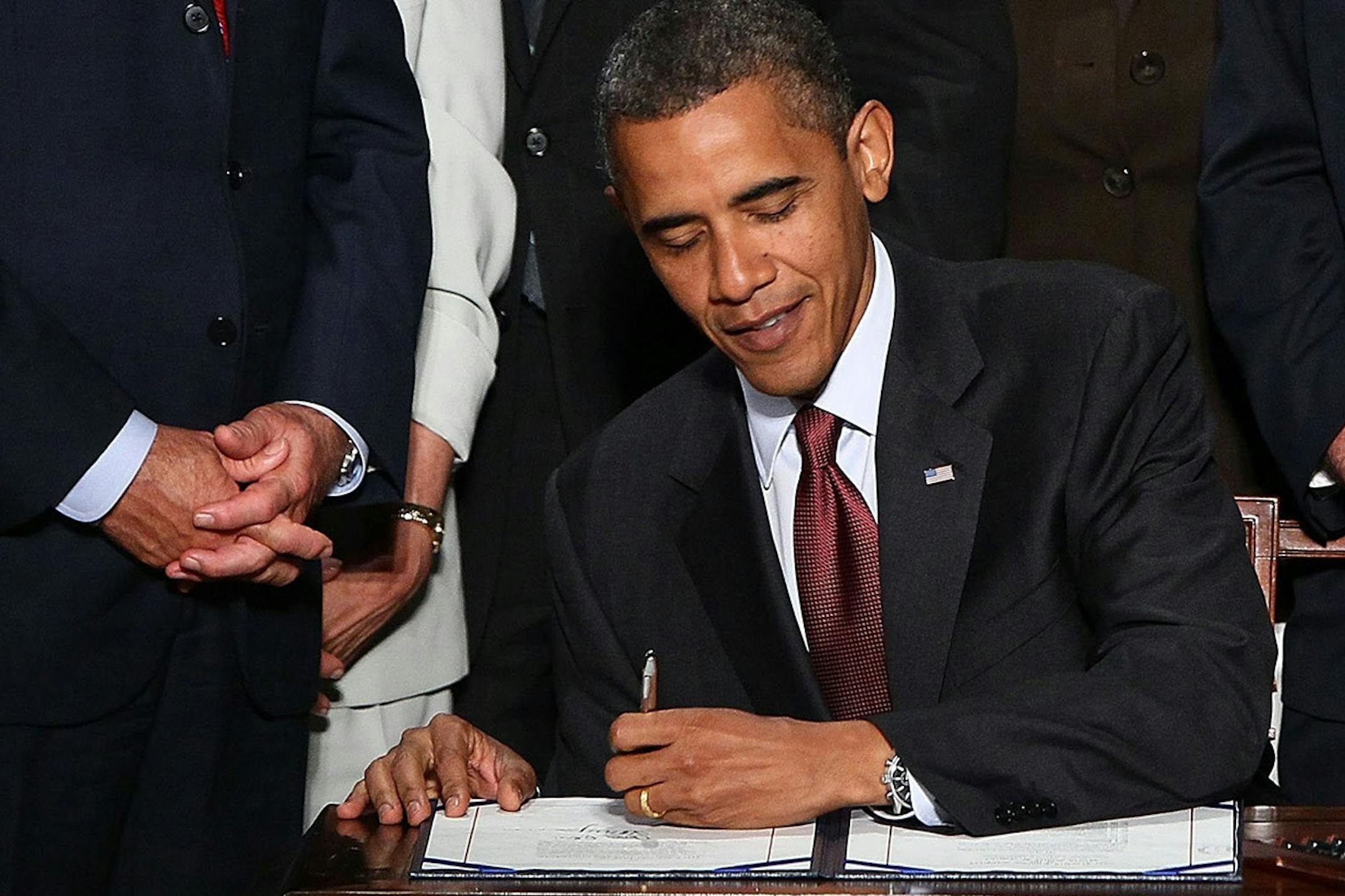 U.S. President Barack Obama signs the Dodd-Frank Wall Street Reform and Consumer Protection Act at the Ronald Reagan Building in Washington, D.C., Wednesday, July 21, 2010. Also pictured, from left, Vice President Joe Biden, Speaker of the House Nancy Pelosi (D-Calif.), Senate Majority Leader Harry Reid (D-Nev.), Rep. Maxine Waters (D-Calif.), Sen. Chris Dodd (D-Conn.) and Rep. Barney Frank (D-Mass.). (Win McNamee/Abaca Press/MCT) ORG XMIT: MIN2013111111042128