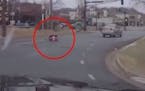 A driver's dashcam video captured the moment when a 2-year-old girl strapped in her car seat tumbled onto the street from her mother's car.
