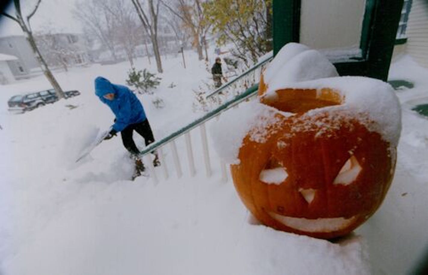 November 1, 1991 Halloween Blizzard feature photos. John Floberg shovels out his walk on James Ave. S. Mpls with a jack o latern a mute witness to the snow. November 3, 1991 Rick Sennott, Minneapolis Star Tribune