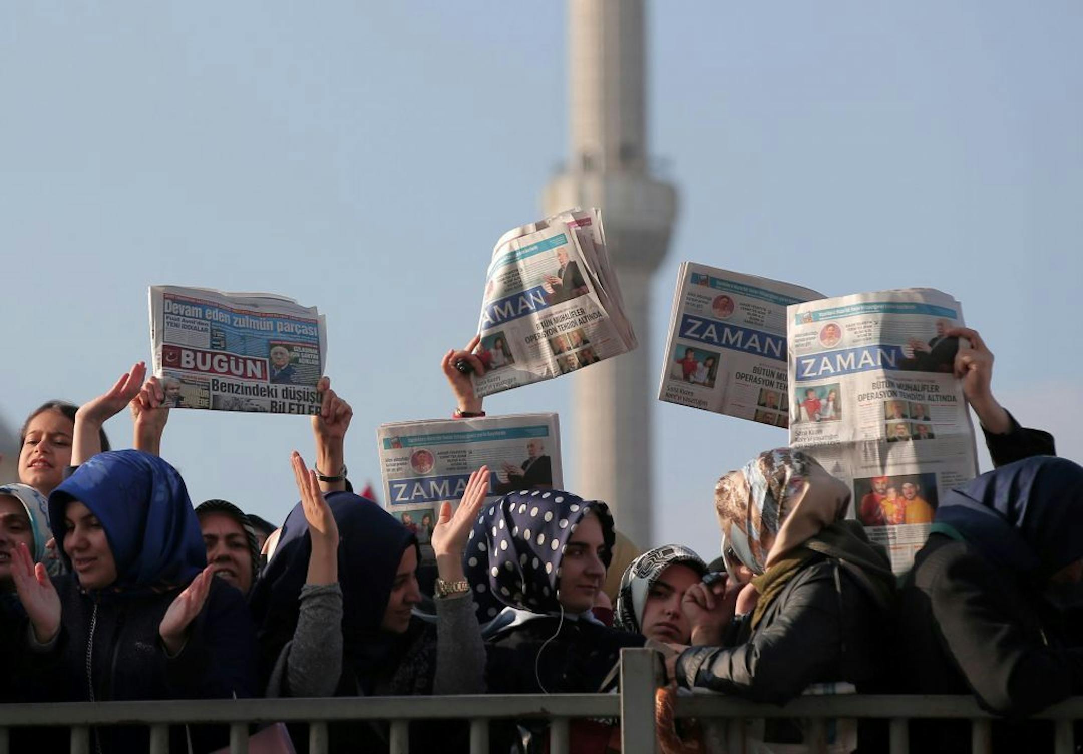 Women hold opposition newspapers as people gather outside the Justice Palace in Istanbul, Turkey, Sunday, Dec. 14, 2014 to protest against the latest detentions in Turkey. Police conducted raids in a dozen Turkish cities Sunday, detaining at least 24 people � including journalists, TV producers and police � known to be close to a movement led by a U.S.-based moderate Islamic cleric who is a strong critic of President Recep Tayyip Erdogan. It was the latest crackdown on cleric Fethullah Gulen's m