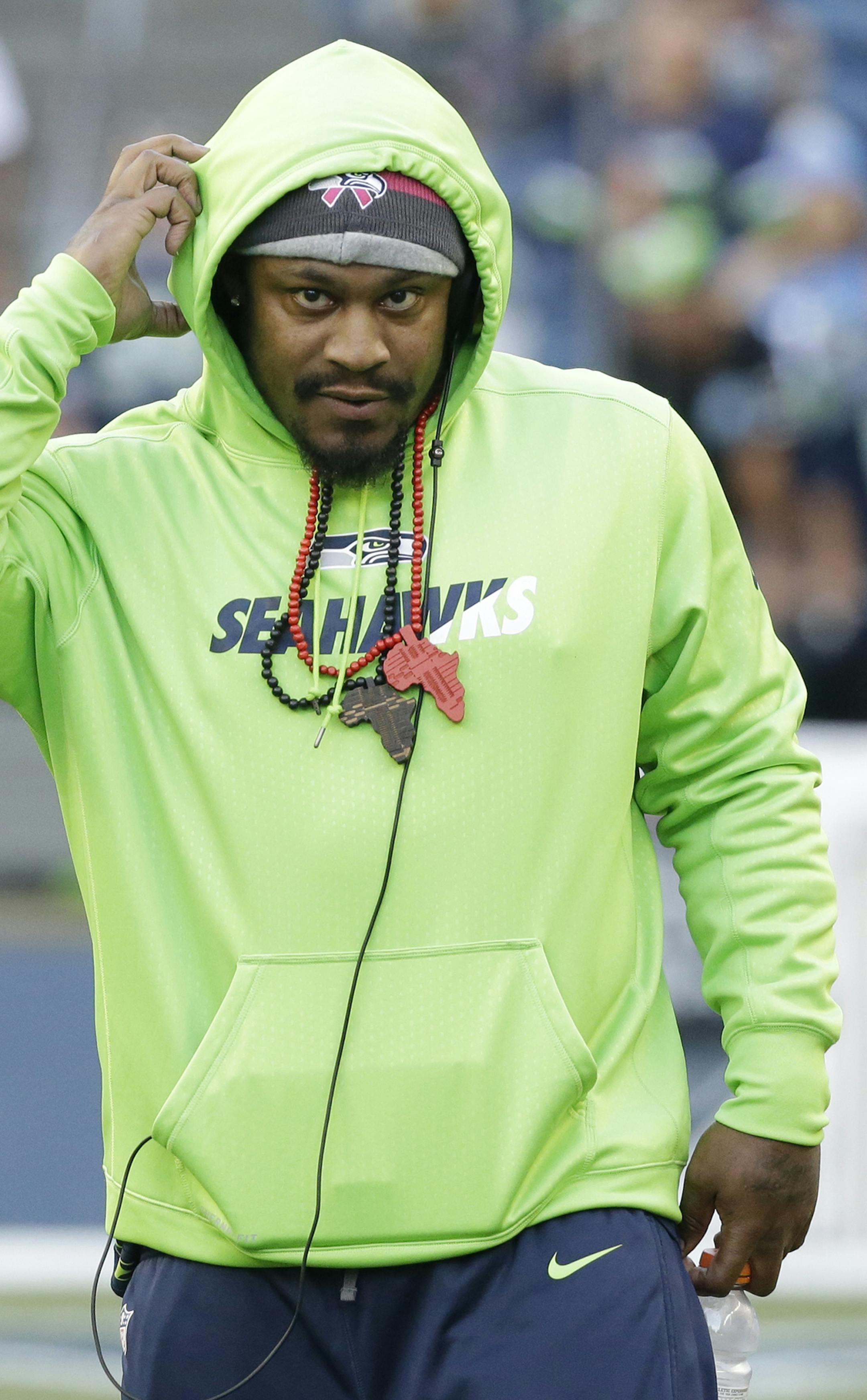 Seattle Seahawks running back Marshawn Lynch walks on the field before an NFL football game against the Detroit Lions, Monday, Oct. 5, 2015, in Seattle. Lynch did not play in the game due to an injury. (AP Photo/Elaine Thompson) ORG XMIT: OTK