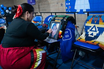 Teddi Wind kneels in front of a picture of her daughter, Navaeh Kingbird, who would have graduated at Bug-O-Nay-Ge-Shig School in Bena on Thursday. Na