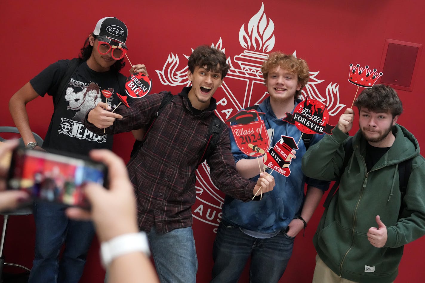 Students, from left, Roman Naatz, Joshua Ford, Brady Laskewitz and Kyle Schweihs, pose for photos after opening letters informing them what Minnesota colleges and universities they've been pre-accepted to as part of the state's Direct Admissions program.