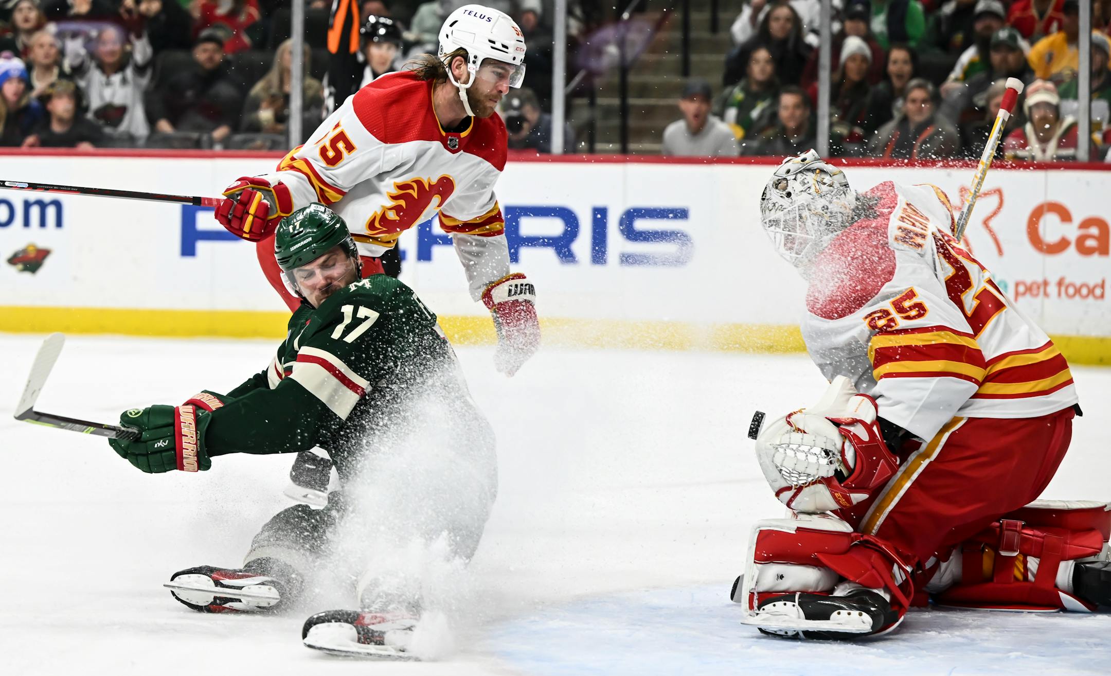 Minnesota Wild left wing Marcus Foligno (17) falls to the ice after he was penalized by Calgary Flames defenseman Noah Hanifin (55), leading to a power play during the first period.