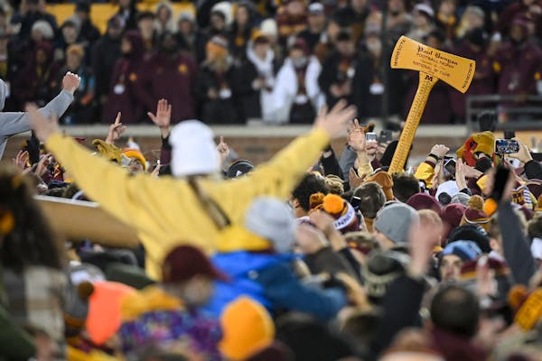 Gophers fans celebrate with Paul Bunyan's Axe after storming the field