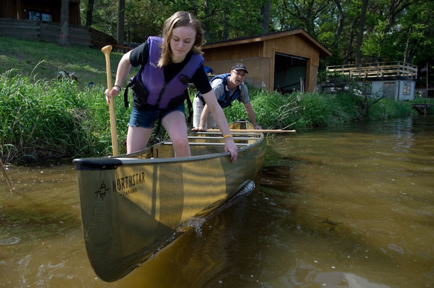 Caitlin Bell and her father, Ted Bell, founder and creator of Northstar Canoes, launched a canoe on Elk Lake in 2014. Northstar is one of nine plantiffs suing suing the Trump administration over a plan to reinstate two long-expired mineral leases near the edge of the Boundary Waters Canoe Area Wilderness.