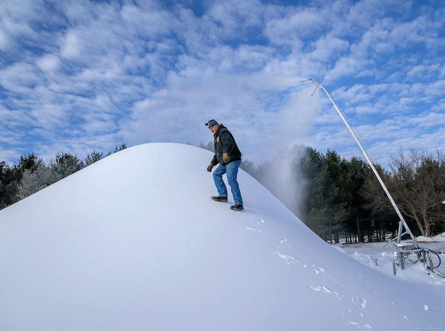 Don Olson, a volunteer, made his way up a mountain of man-made snow to gauge the amount that he and other volunteers were taking out to spread over the trails to groom at Vasoloppet Nordic Ski Center, Thursday, January 10, 2019 in Mora, MN. The Center is run purely by volunteers and donations. ] ELIZABETH FLORES &#x2022; liz.flores@startribune.com