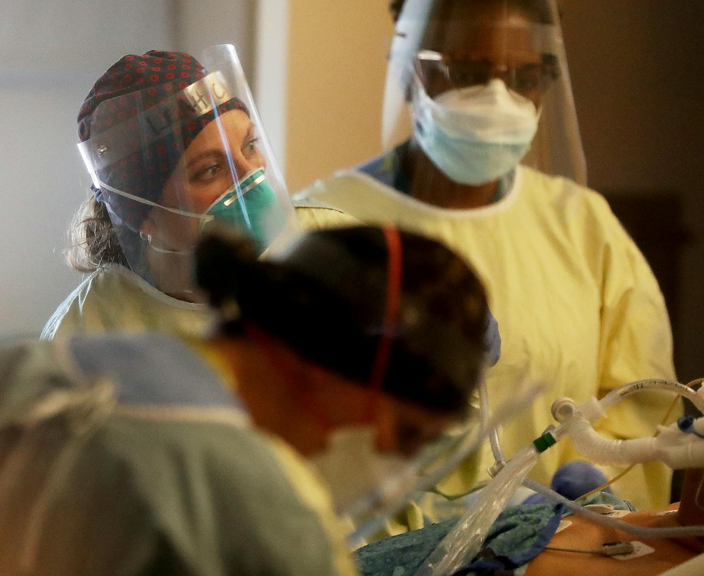 Healthcare workers monitor a COVID-19 patient in an ICU at Bethesda Hospital in St. Paul in May. Every time a COVID-19 patient leaves Bethesda Hospital alive, a bell rings throughout the St. Paul facility. Its a moral-booster for doctors and nurses -- as they struggle with a vexing disease, limited protective supplies, and the threat of many, many more cases to come when the state eases off its social distancing strategies.