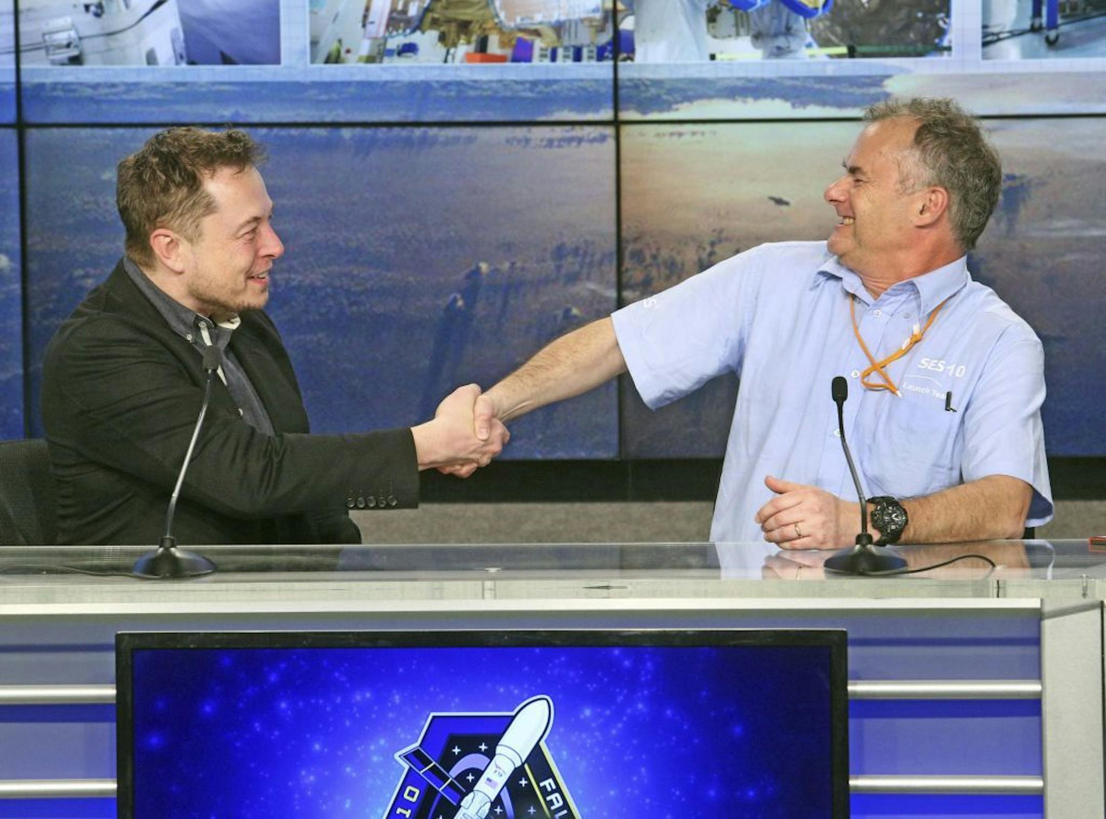 SpaceX CEO Elon Musk, left, shakes the hand of CTO Martin Halliwell, SES Satellites, at Kennedy Space Center in Cape Canaveral, Fla., after a SpaceX Falcon 9 rocket blasts off from the space center on Thursday, March 30, 2017. SpaceX launched its first recycled rocket Thursday, the biggest leap yet in its bid to drive down costs and speed up flights.