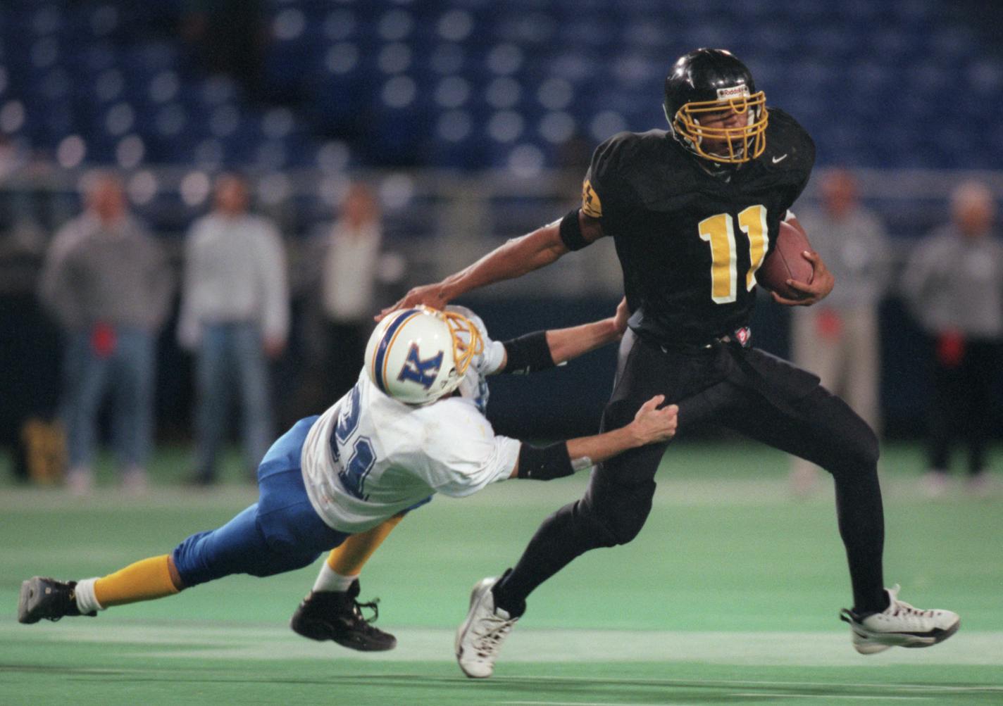 MINNEAPOLIS - 11/26/99 - De La Salle High School in Minneapolis crushed St. Michael - Albertville 28 - 7 for the Class AAA football championship Friday afternoon in the Metrodome. — De La Salleís Rod Malone (11) broke free of St. Michael - Albertvilleís Travis Zachman (21) for a 43 yard gain and a second quarter touchdown.