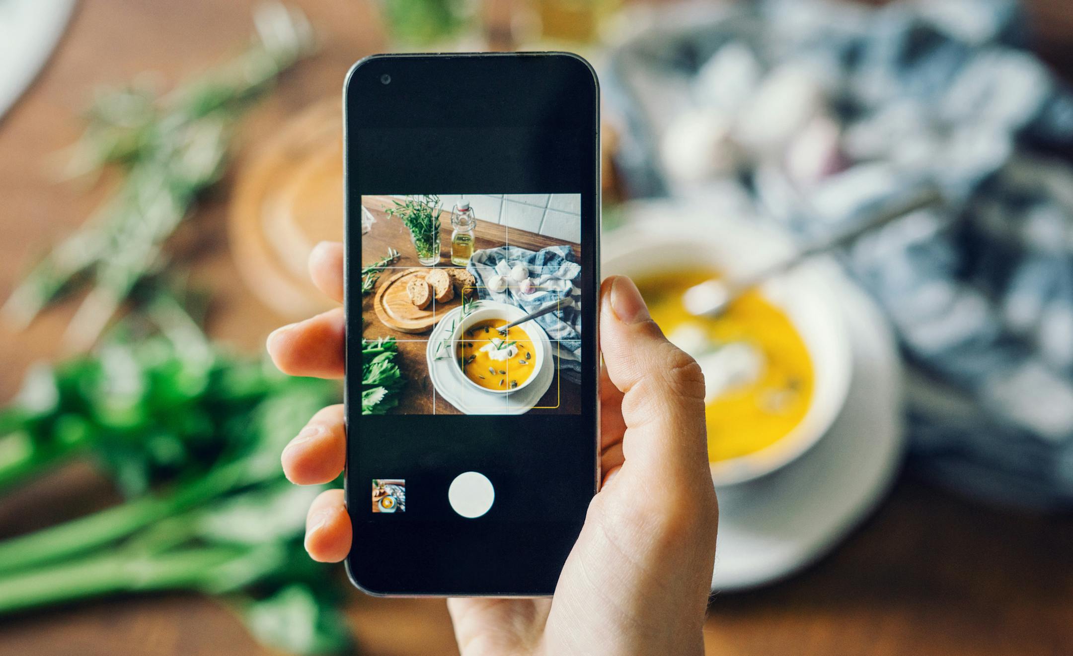 Woman taking photo of pumpkin soup with smartphone. istock