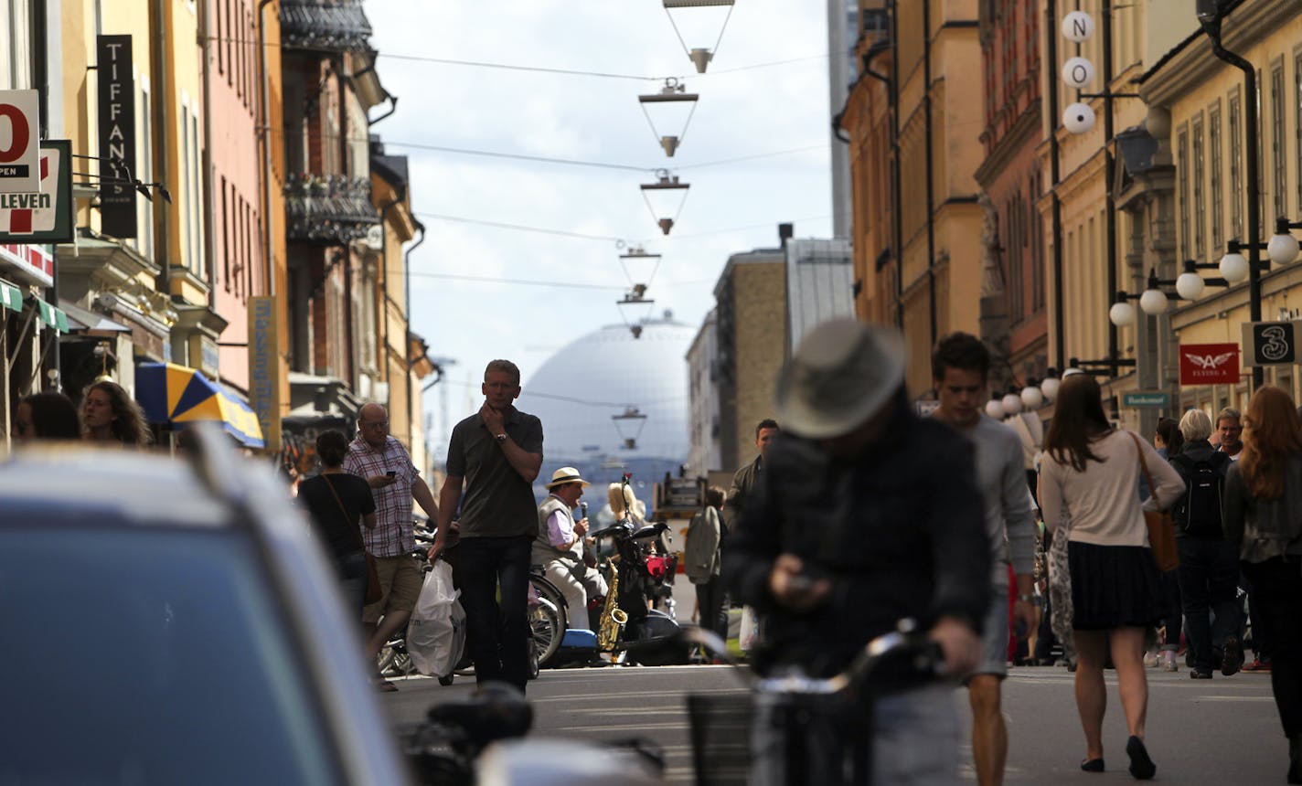 The Ericsson Globe Arena, the world's largest spherical building, is seen in the background as pedestrians walk the streets of the Sodermalm neighborhood of Stockholm, Sweden Saturday, June 30, 2012.](DAVID JOLES/STARTRIBUNE) djoles@startribune.com Travel story on Sweden.]