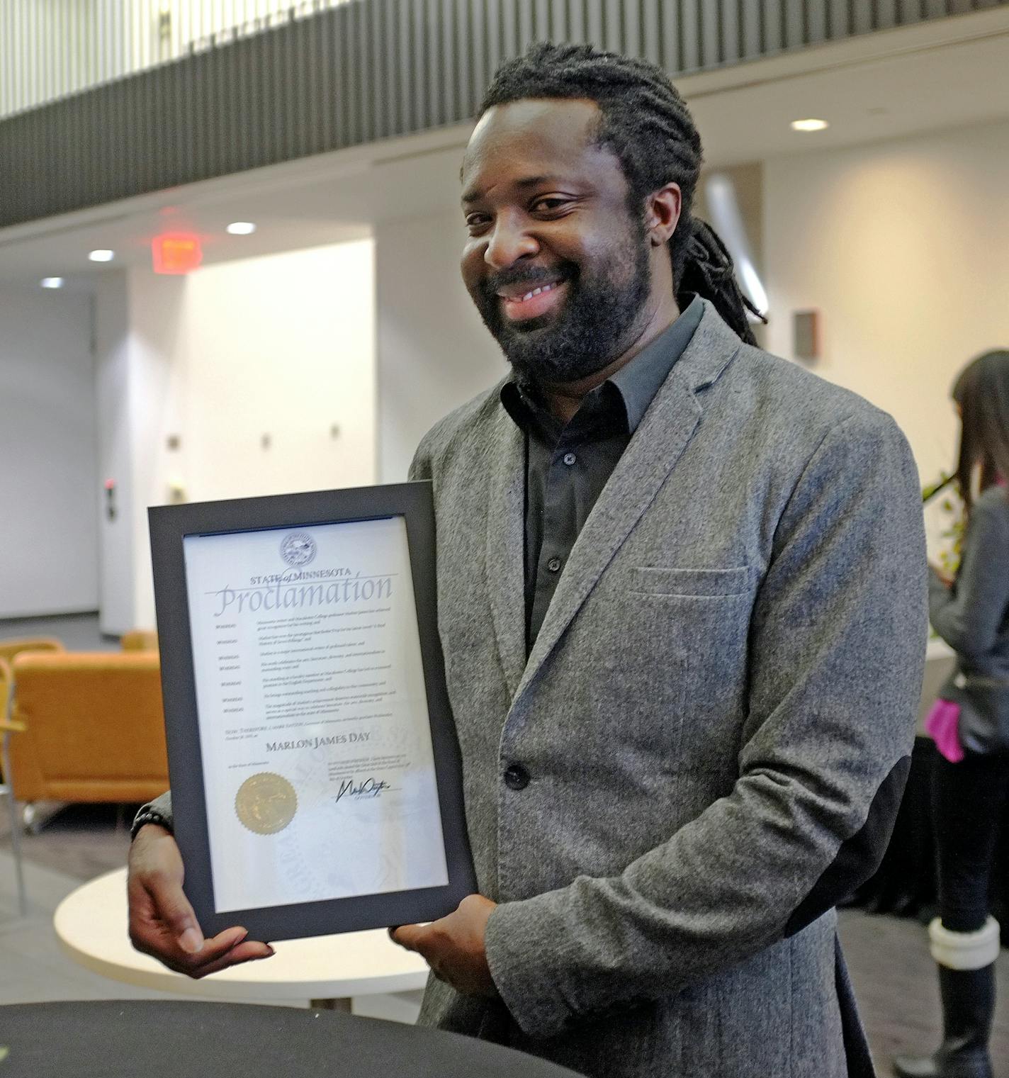 Marlon James poses with Gov. Mark Dayton's proclamation of Marlon James Day, Oct. 28, 2015, in Minnesota. James, a professor at Macalester College, is the author of "A Brief History of Seven Killings," which won the Man Booker Prize, one of the literary world's most esteemed awards.