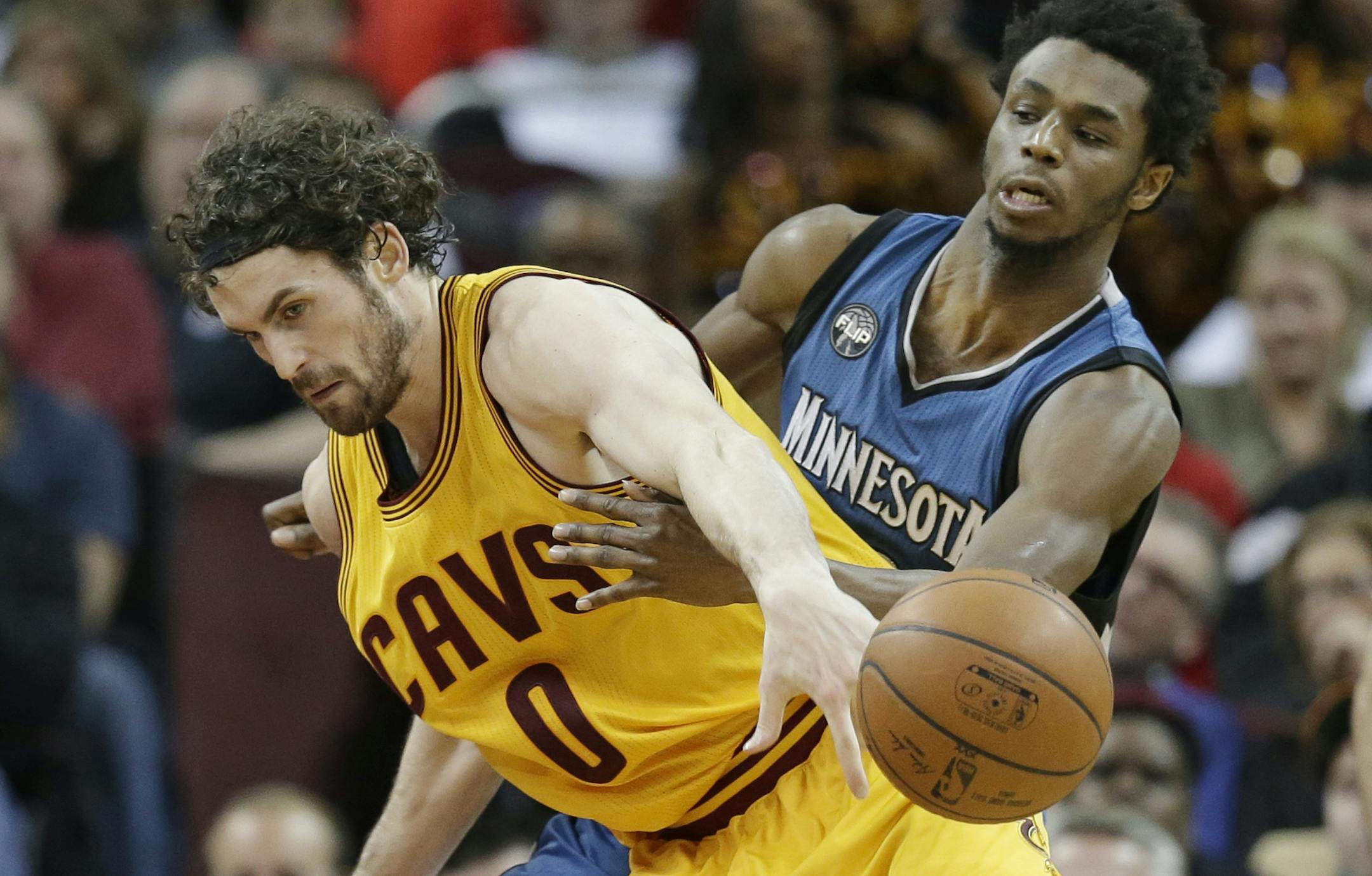 Minnesota Timberwolves' Andrew Wiggins, right, from Canada, knocks the ball loose from Cleveland Cavaliers' Kevin Love in the second half of an NBA basketball game Monday, Jan. 25, 2016, in Cleveland. The Cavaliers won 114-107. (AP Photo/Tony Dejak)