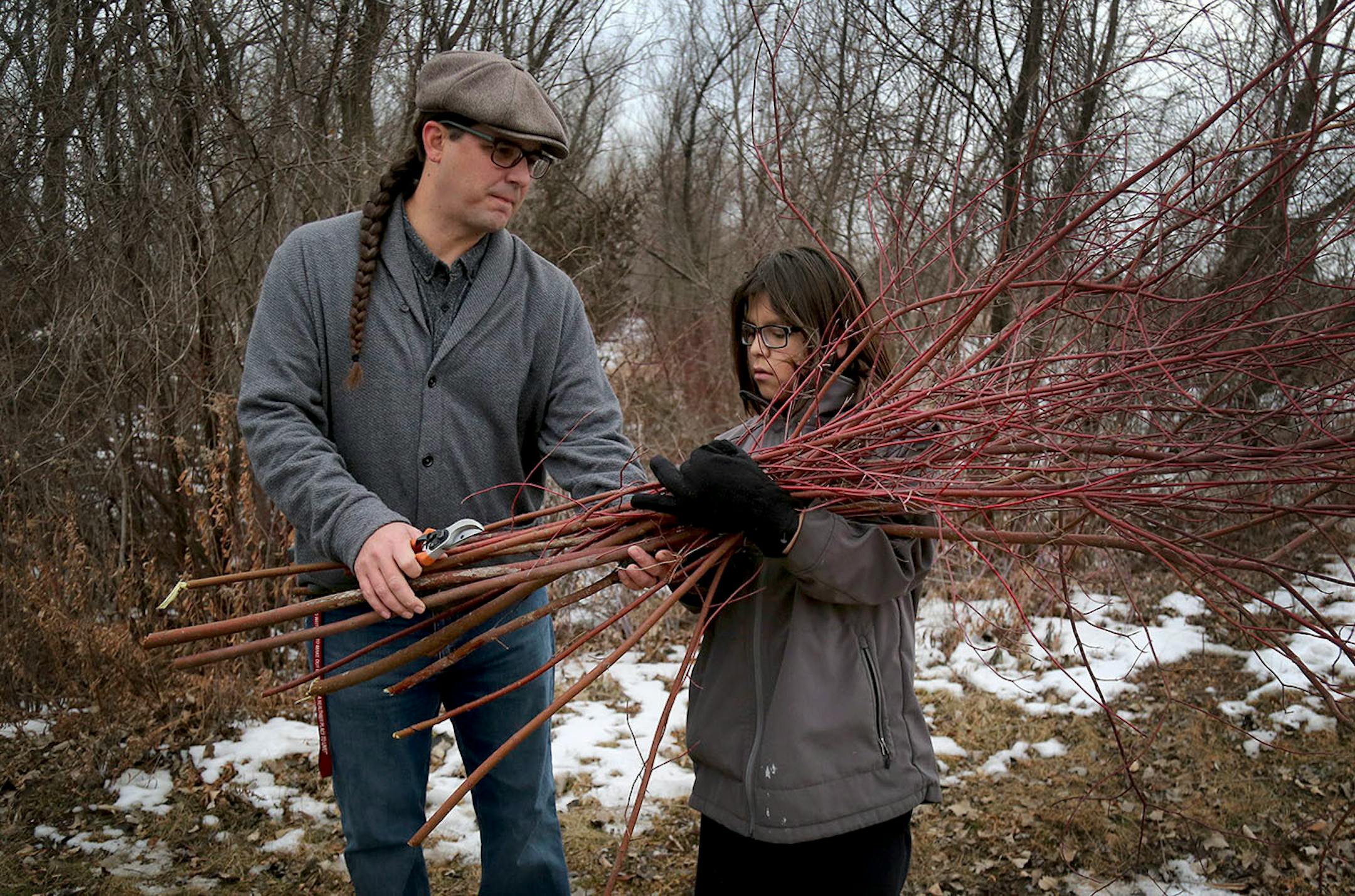 Elliot Christensen, tobacco prevention coordinator for the Lower Sioux Community, left, takes a load of red willow from his son Blayden, 11.