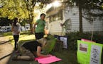 Antonia Alvarez stood with Luann Zappa while she made another sign for the Lowry Grove tenants group Thursday evening. At left was Alvarez's daughter,