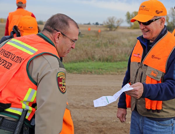 DNR conservation officer Lt. Gary Nordseth checked Gov. Dayton's license before the governor went afield on the first day of the 2017 ringneck season.