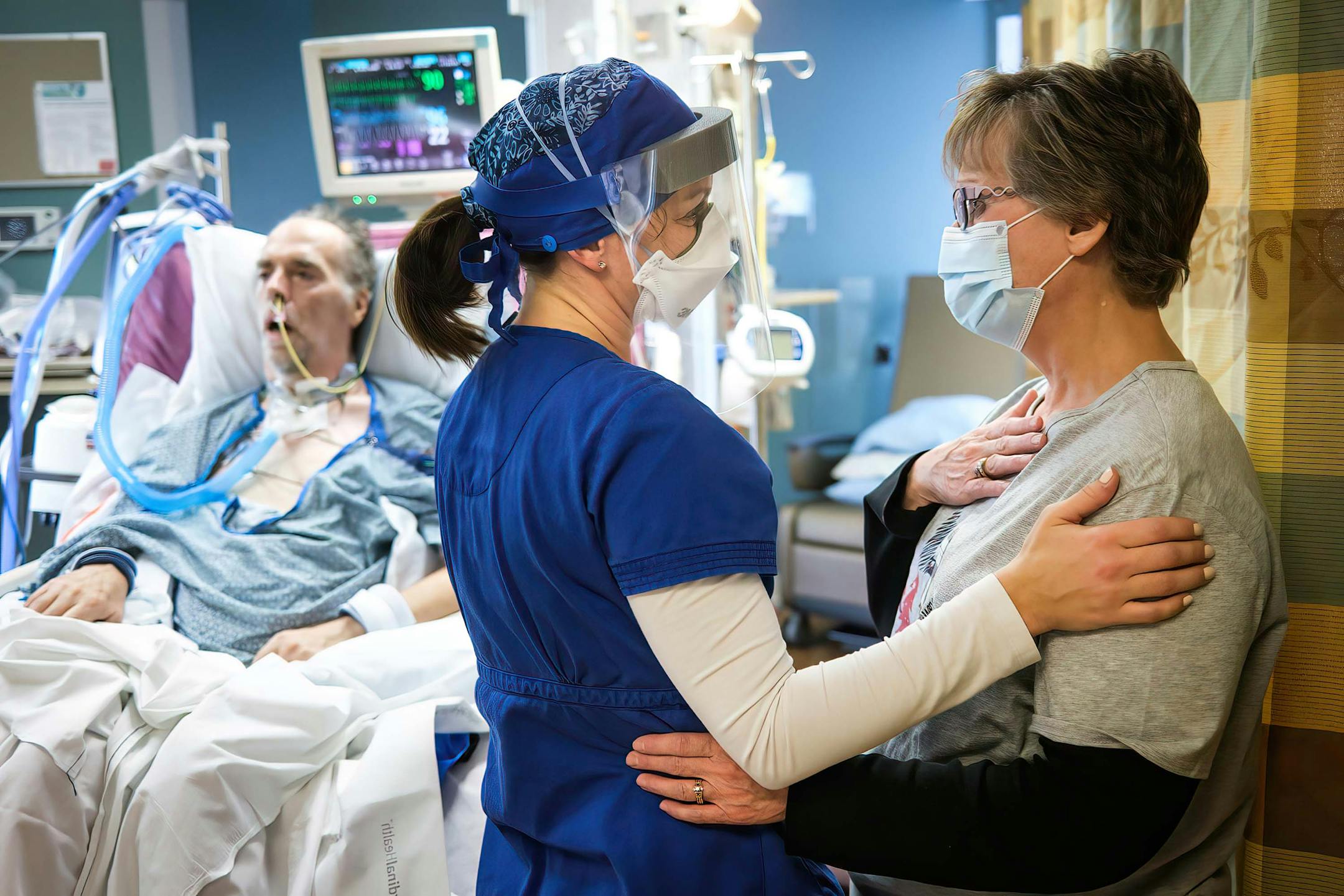 In 2020, critical care nurse Holly Vilione and Deb Ulrich, of Norwood Young America, comforted each other as Deb visited her husband Rick, for the first time since his hospitalization with COVID-19. Vilione had been caring for her husband for weeks and was constantly updating Deb over the phone.