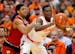 Syracuse's Tyler Roberson, right, looks to pass the ball under pressure from Louisville's Wayne Blackshear, left, in the first half of an NCAA college
