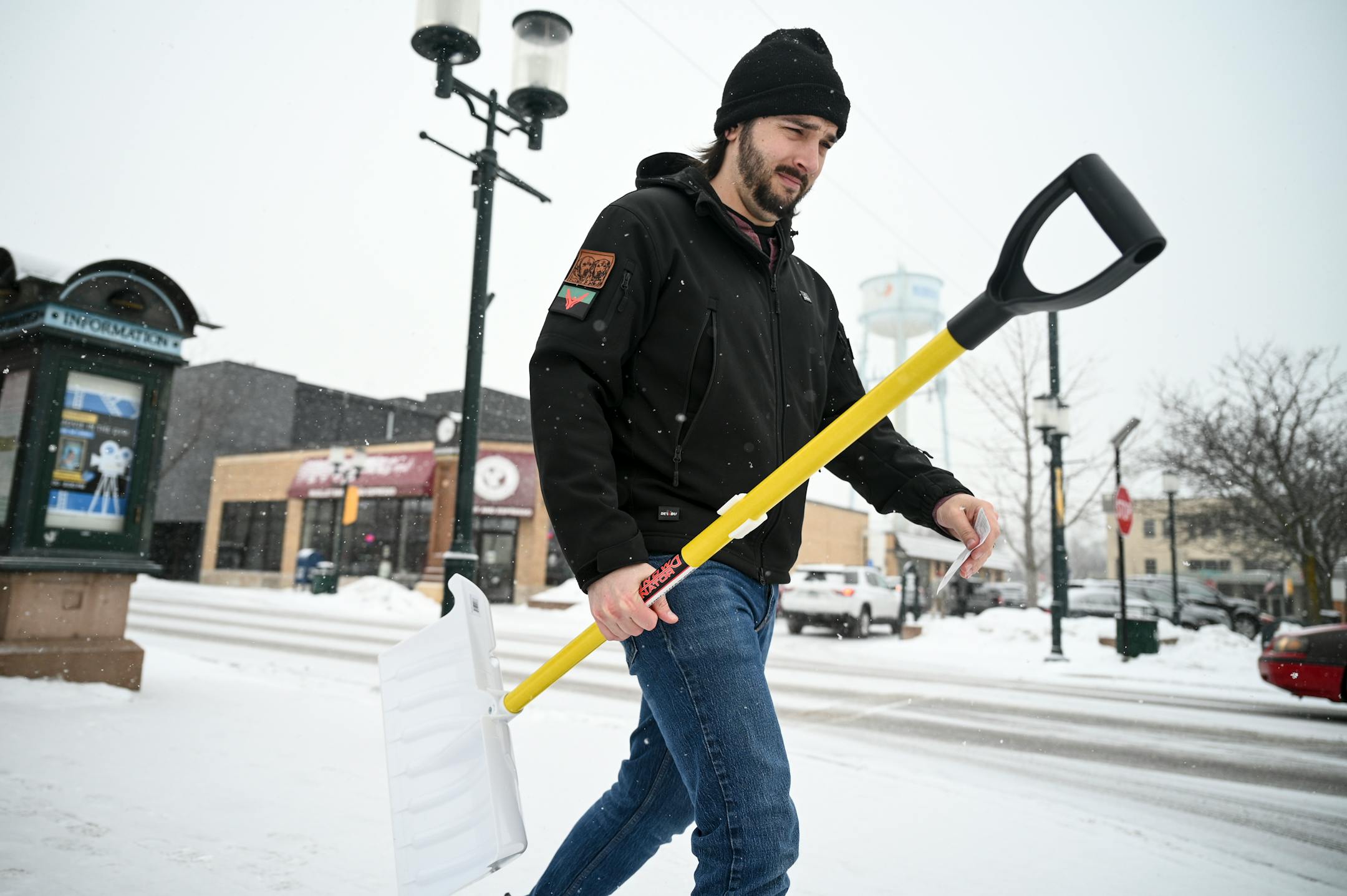 Gavin Colahan, of Crystal, carries a just-purchased spare snow shovel to his car outside Welna's Ace Hardware in Robbinsdale.