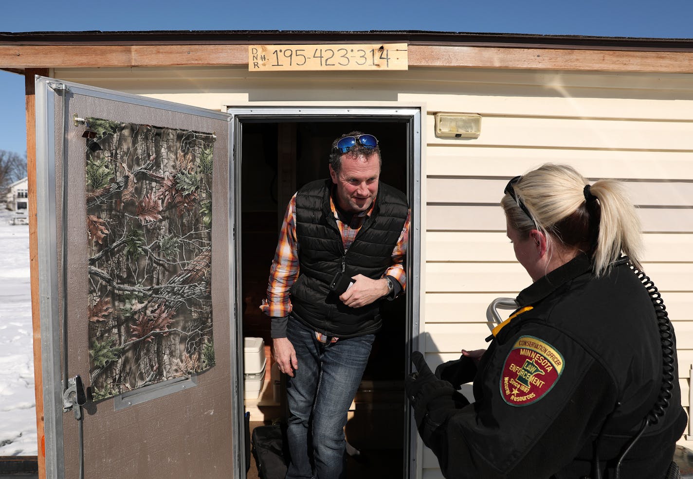 Minnesota Department of Natural Resources conservation officer Leah Weyandt talked with angler Darrin Stuhr of Eden Prairie about the upcoming deadline to remove ice fishing shelters Thursday at Lake Minnetonka. ] ANTHONY SOUFFLE &#xef; anthony.souffle@startribune.com Minnesota Department of Natural Resources conservation officers Brent Grewe and Leah Weyandt talked with anglers about the upcoming deadline to remove their ice fishing shelters Thursday, March 1, 2018 on Lake Minnetonka in Wayzata