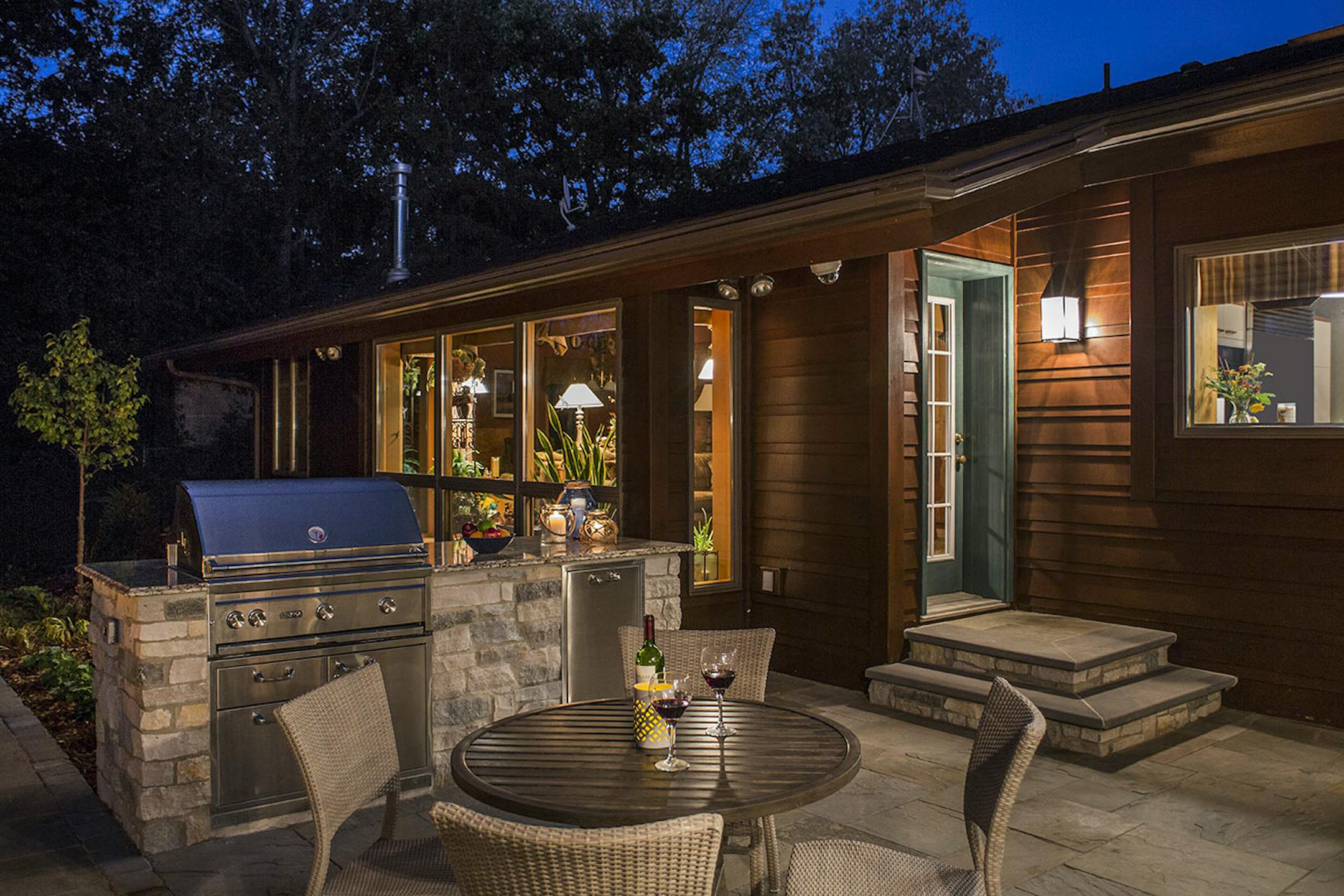 The outdoor kitchen includes a grill and trash station.