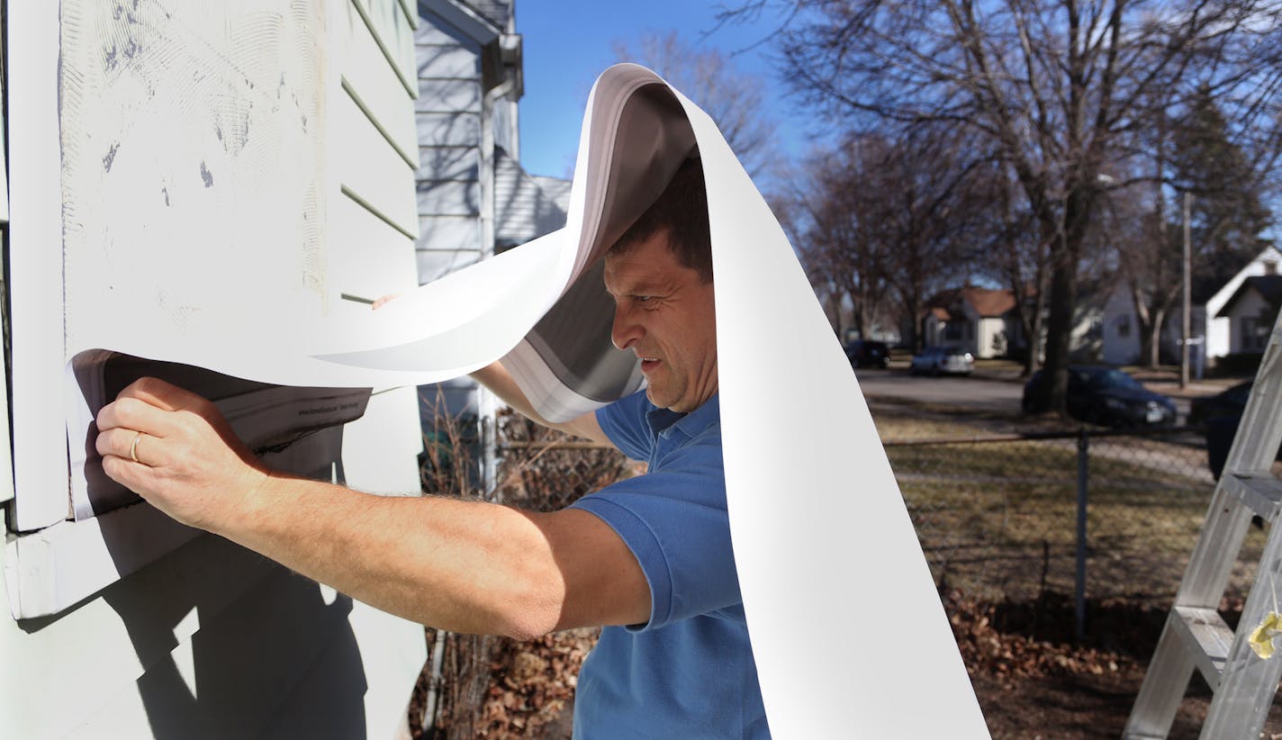 Tim Korby, of Korby's Handyman Services, installed the vinyl coverings onto the boarded up windows on this home. ] (KYNDELL HARKNESS/STAR TRIBUNE) kyndell.harkness@startribune.com At a forfeited home in Minneapolis Min., Thursday, March 31, 2014. Hennepin county installed the vinyl covering for the boarded up windows and door it has purchased from Michigan-based Home Illusions.