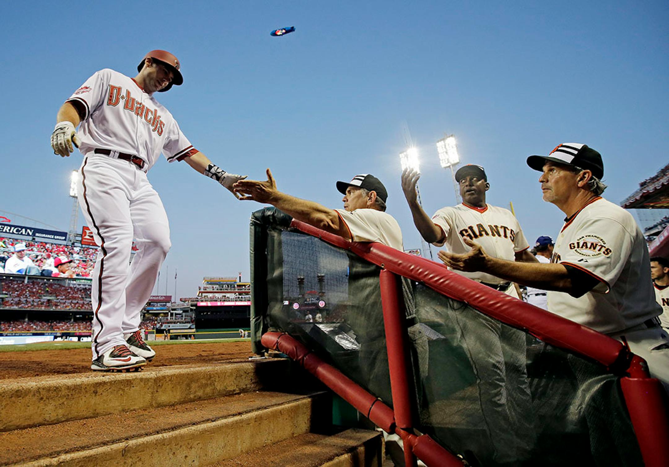 National League's Paul Goldschmidt, of the Arizona Diamonbacks, is congratulated by National League manager Bruce Bochy, of the San Francisco Giants, after scoring a run on a hit by National League's Jhonny Peralta, of the St. Louis Cardinals, during the second inning of the MLB All-Star baseball game, Tuesday, July 14, 2015, in Cincinnati.