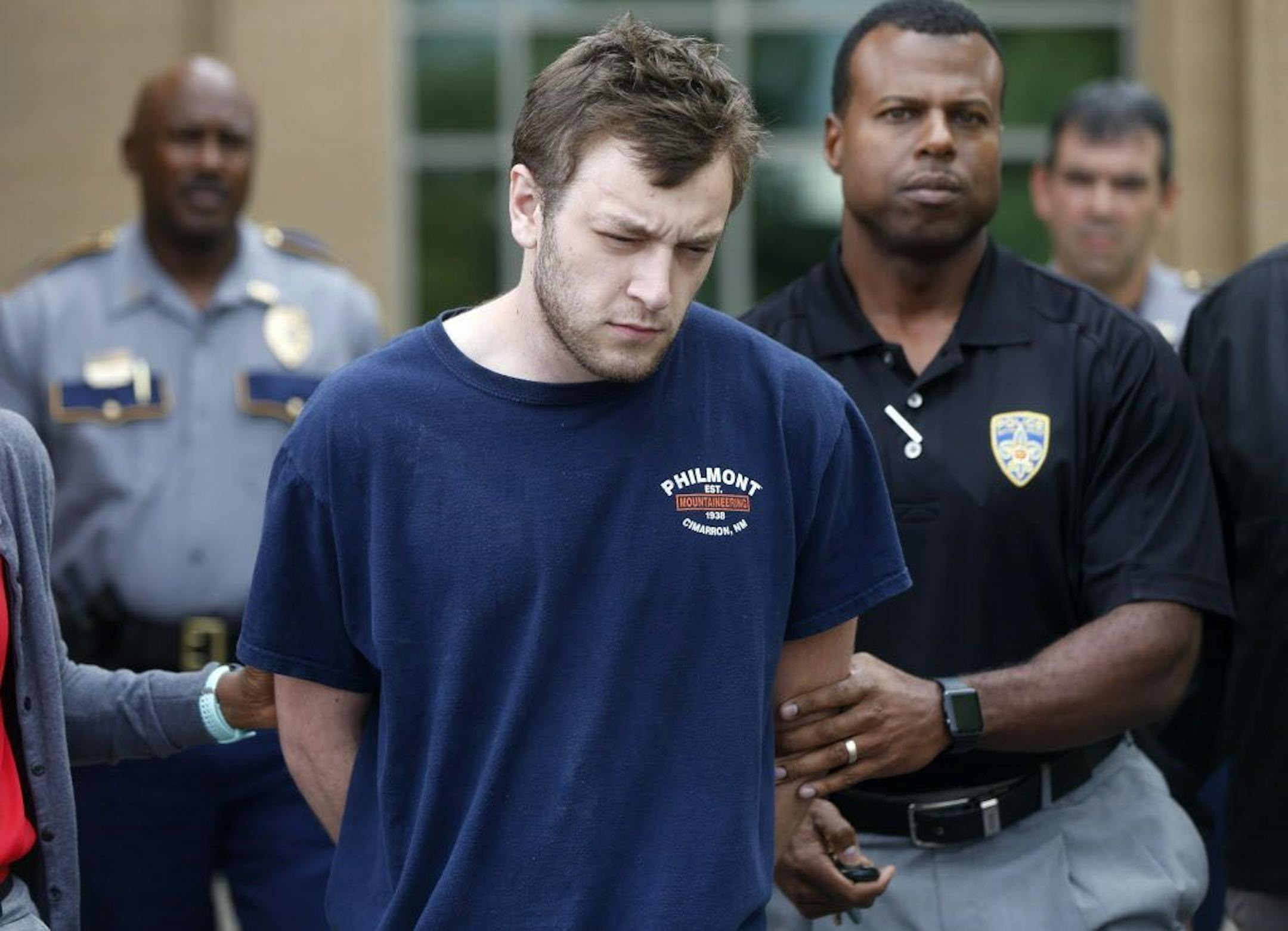 Kenneth James Gleason is escorted by police to a waiting police car in Baton Rouge, La., Tuesday, Sept. 19, 2017. Gleason is charged with two counts of first degree murder and other charges, for three shootings in the Baton Rouge area throughout the past week that resulted in the death of two men.