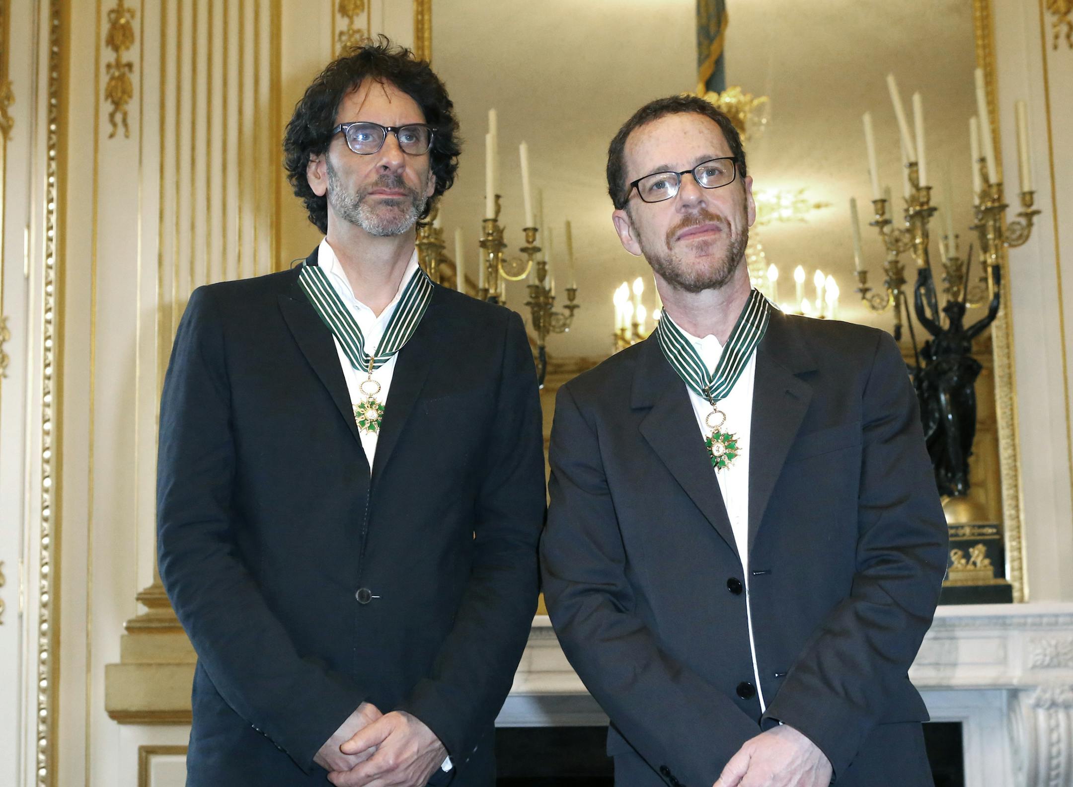 U.S directors Joel Coen, left, Ethan Coen, pose for photographers after being awarded the medals of Commandeur de l'Ordre des Arts et Lettres (Commander of the Order of Arts and Letters) during a ceremony at the Culture Ministry in Paris on Wednesday, Oct. 16, 2013.(AP Photo/Jacques Brinon)