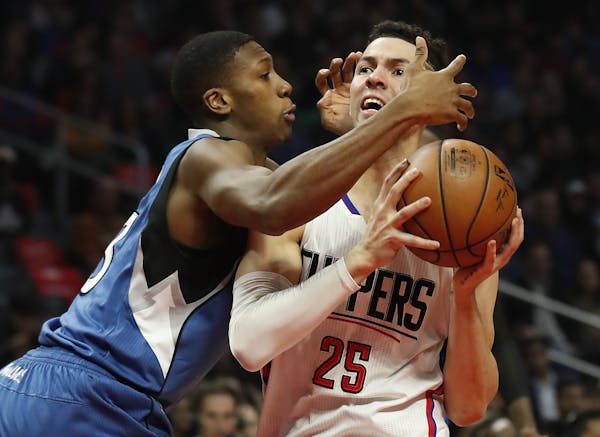 Minnesota Timberwolves guard Kris Dunn, left, defends Los Angeles Clippers guard Austin Rivers during the first half of an NBA basketball game, Thursd