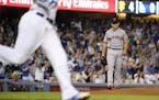 San Francisco Giants starting pitcher Matt Moore, right, looks toward first as Los Angeles Dodgers' Corey Seager runs after Seager broke up his no-hit