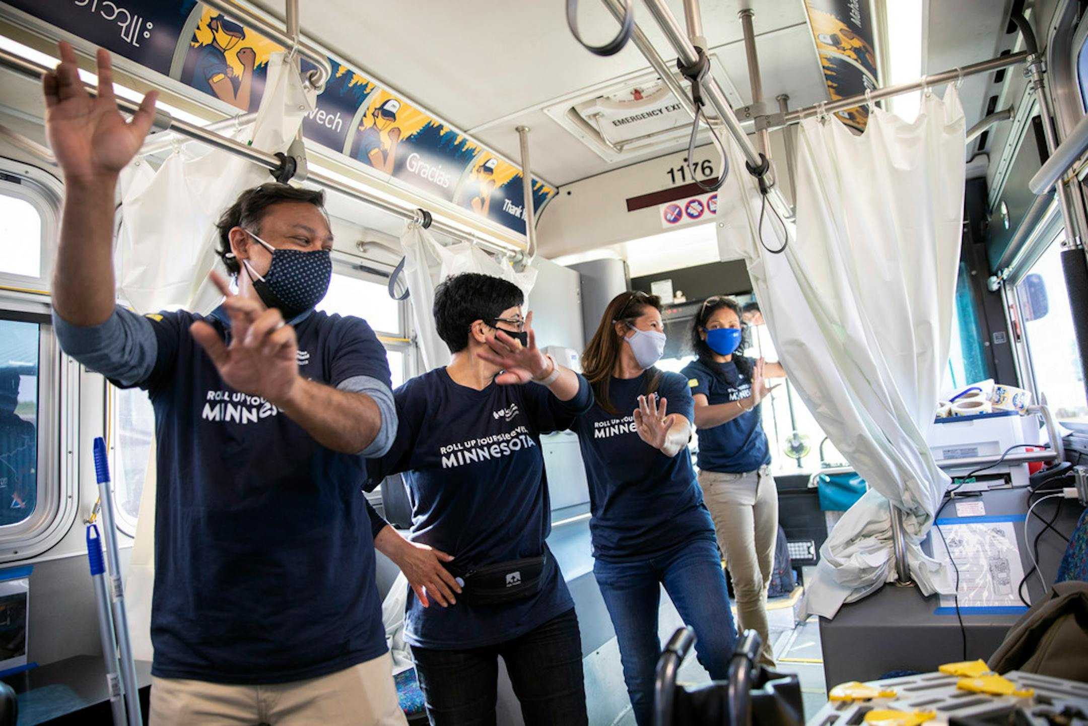 Vaccine administration volunteers dance to celebrate a successful day of work at a mobile COVID-19 vaccination clinic in Foley, Minn., on May 12, 2021. Mobile vaccine clinics in vans and buses are rolling up to neighborhoods in Delaware, Minnesota and Washington State to reach people who have been unable to travel to vaccination centers. (Liam James Doyle/The New York Times)