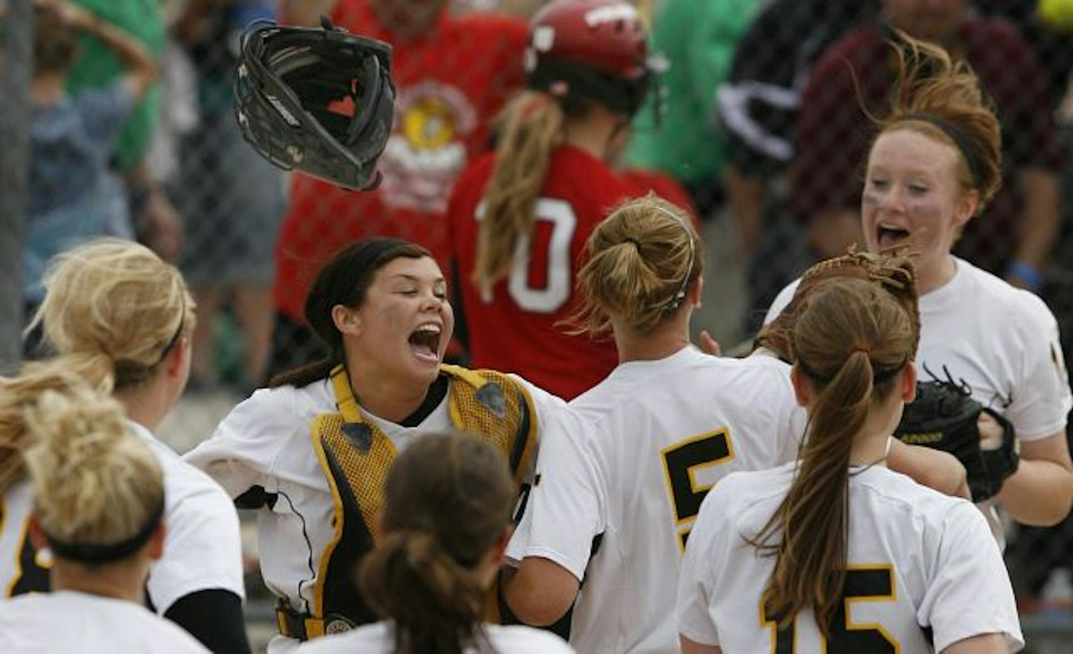 The mask of Burnsville catcher Maggie Dunsmore (facing camera, middle) flew in the air as she celebrated with her teammates after winning the game, 3-2, over North.