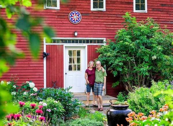Gardener Lisa Moran and her husband, Peter Rekow, in one of their gardens in front of their 19th-century granary, now a studio.