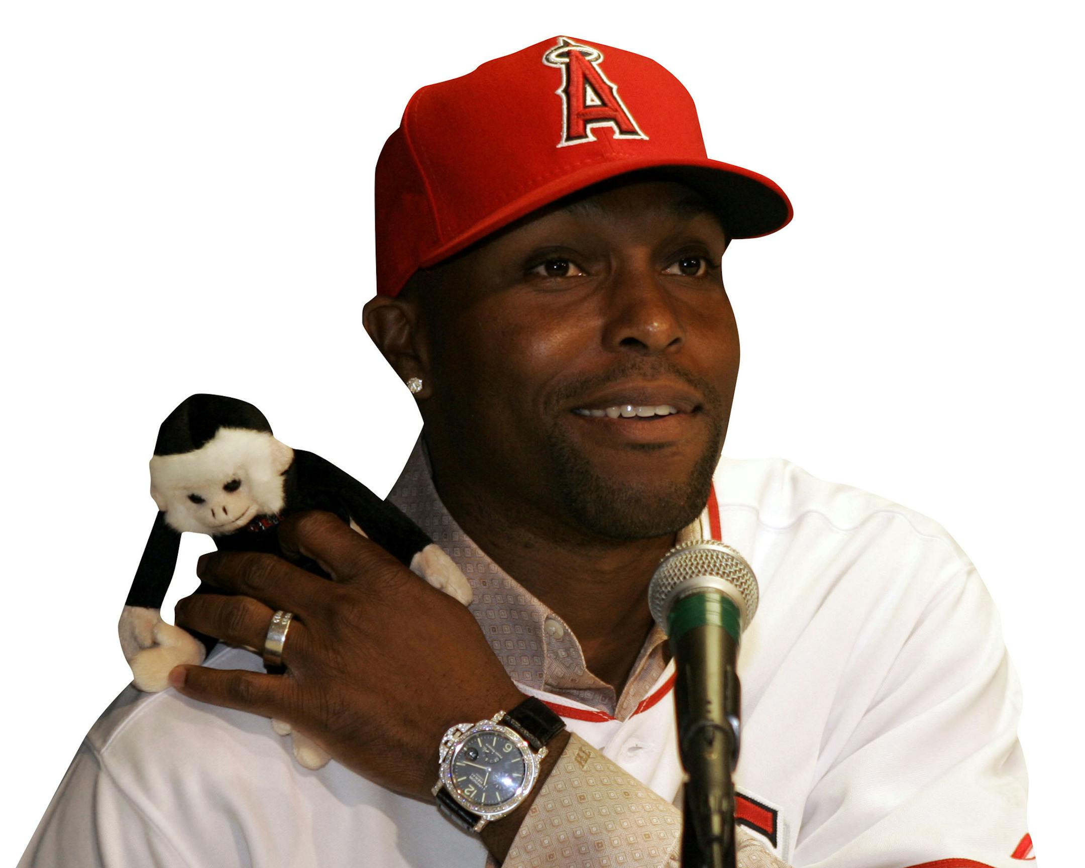 Baseball player Torii Hunter, newly acquired by the Los Angeles Angels, jokes about the rally monkey during a news conference Wednesday, Nov. 28, 2007, in Anaheim, Calif. (AP Photo/Ric Francis) ORG XMIT: CARF103