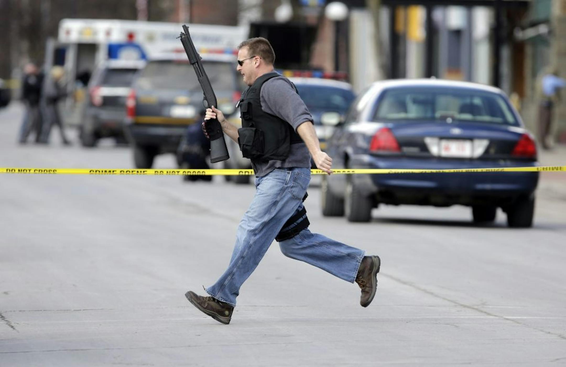 Law enforcement officers run for cover along Main Street in Herkimer, N.Y., when shots were fired.